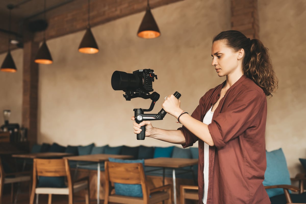 Professional woman videographer with stabilizer gimball video slr