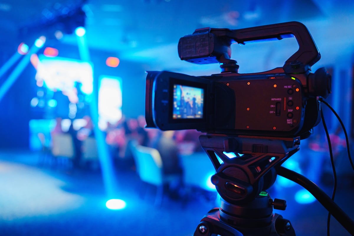 A professional videographer is filming on stage