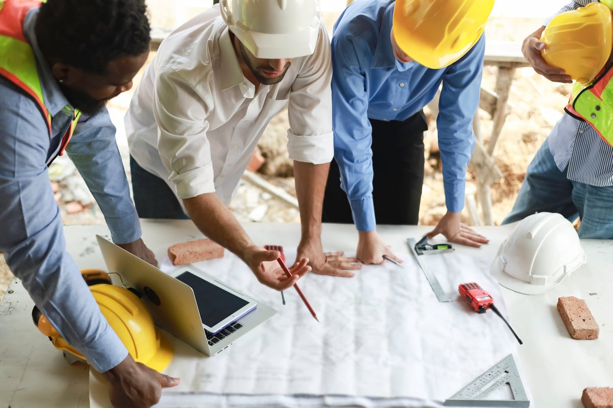 A group of engineers and staff met to discuss and work together to assess the progress of the residential construction site